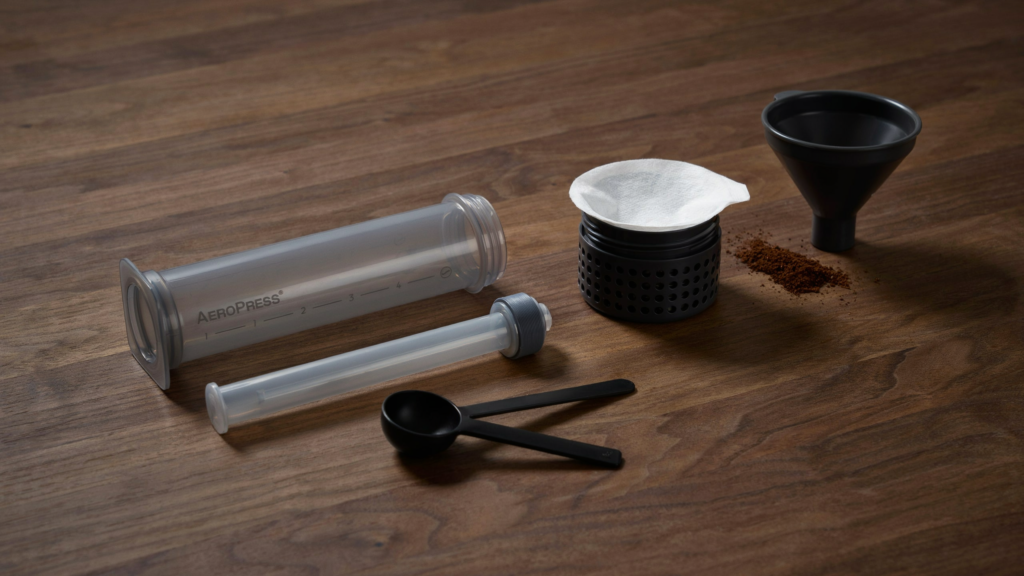 Aeropress em design clássico sobre mesa de escritório, remetendo à sua origem como invenção de engenharia.